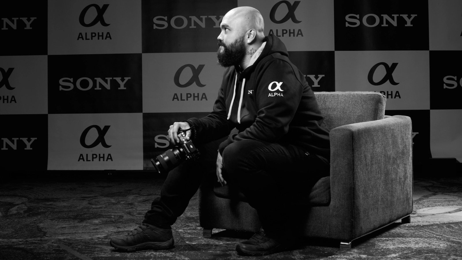 Jhonattan Vanegas seated holding a camera at a Sony Alpha event